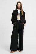 Pantalon à doubles pinces et jambes évasées en crêpe porté – Please Femme